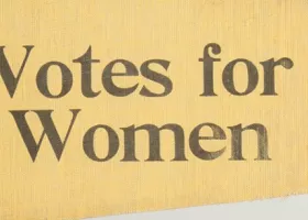 yellow flag with the words "Votes for Women" stenciled in black