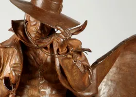 sculpture of a cowboy tipping his hat down