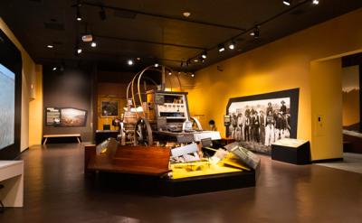 museum gallery with yellow colored walls chuck wagon is featured