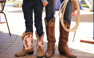 Close up of two children's cowboy boots and rope