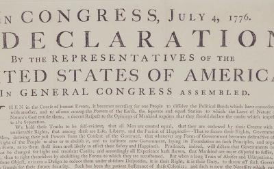 A close-up of the top portion of the United States Declaration of Independence, dated July 4, 1776, showing the title and introductory text in large, bold letters.