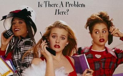 Three young women in 1990s fashion hold large cell phones and planners, standing on a staircase. Above them, text reads “Is There A Problem Here?” They look surprised or concerned.