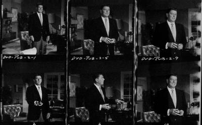 A black-and-white contact sheet showing six photos of a man in a suit, standing and holding objects in a living room setting. Handwritten labels and numbers are visible above and below the images.