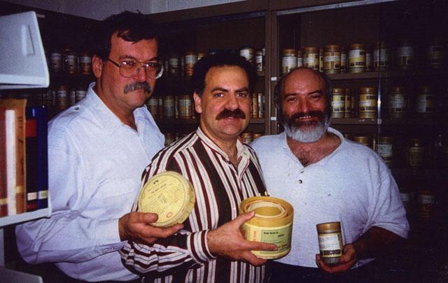 Three men standing holding wax cylinder cases