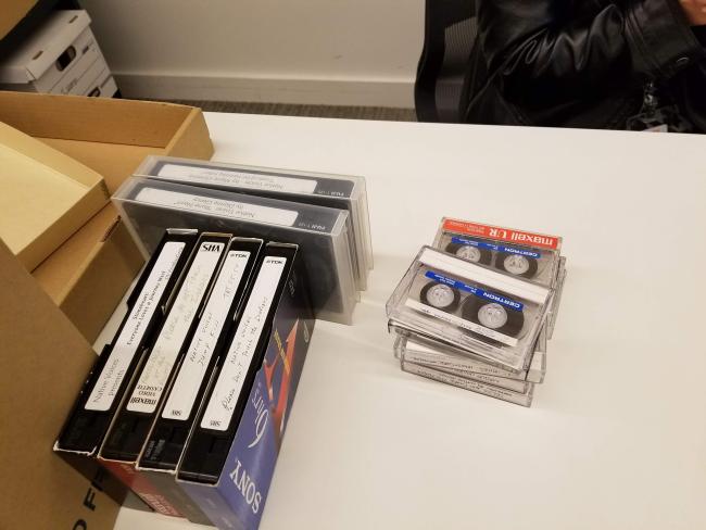 three sizes of cassette tapes and some storage boxes on the side