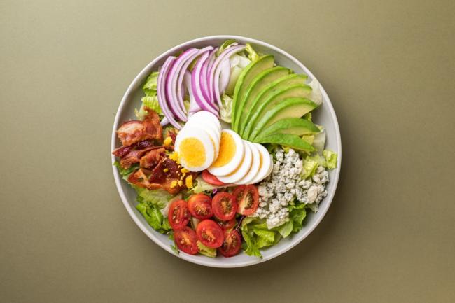 view from top of salad with bacon avocado egg tomato and more 