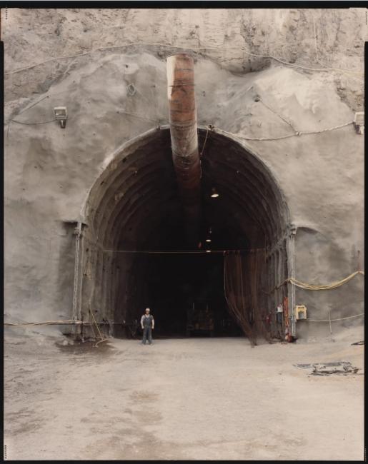 Tunnel with worker standing next to it 