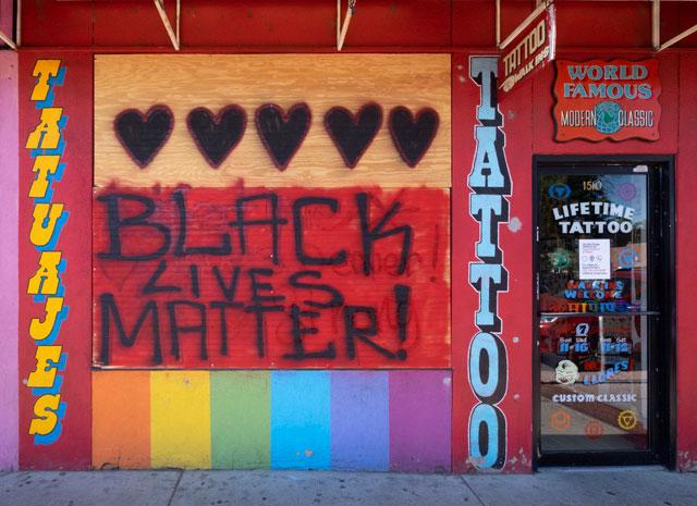 boarded up store front with BLM art