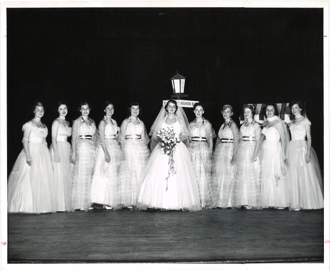 young women in long white formal dresses posing for a formal group picture
