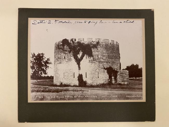 photograph in matting of a historic building, there is writing on the photograph
