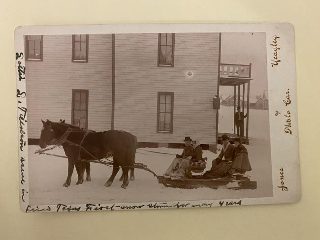 horse-drawn snow sled holding two couples