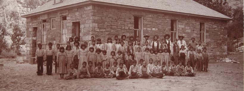 group of students standing in front of a stone building