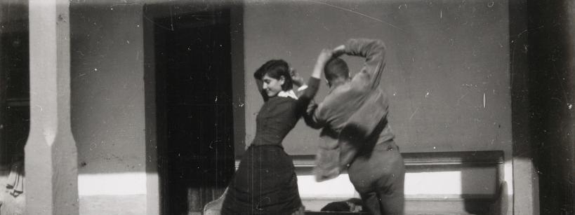 man and woman dancing mid-twirl with arms above and back to back