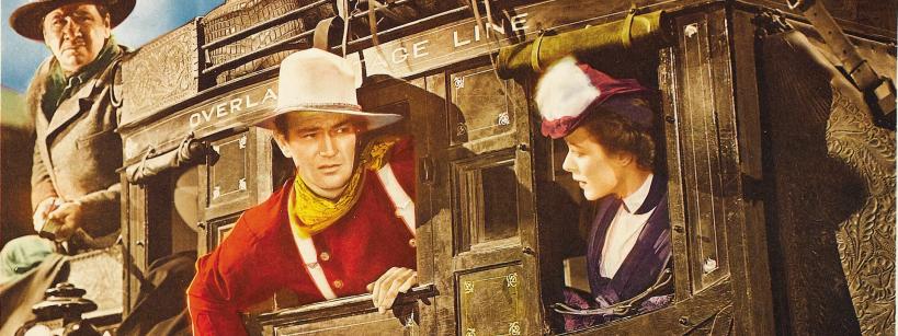 Three people in Old West attire ride a stagecoach. A man in a white hat and red shirt looks ahead, a woman in a purple dress peers out the window, and a driver sits on top, holding the reins. The coach reads “Overland Stage Line.”.