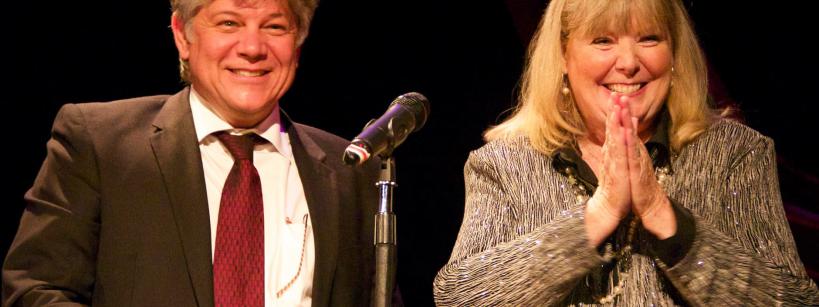 Happy man and woman stand at podium