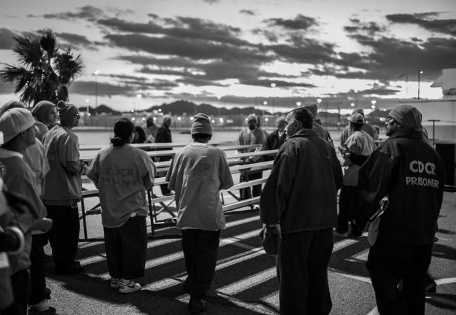 A group of inmates gather at sunrise