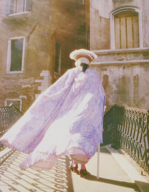 person walking away wearing an old style venetian costume