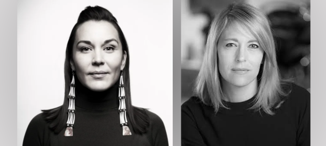 Black and white photo of two women in dark tops; the woman on the left wears long beaded earrings, while the woman on the right has shoulder-length hair. Both face the camera with neutral expressions.