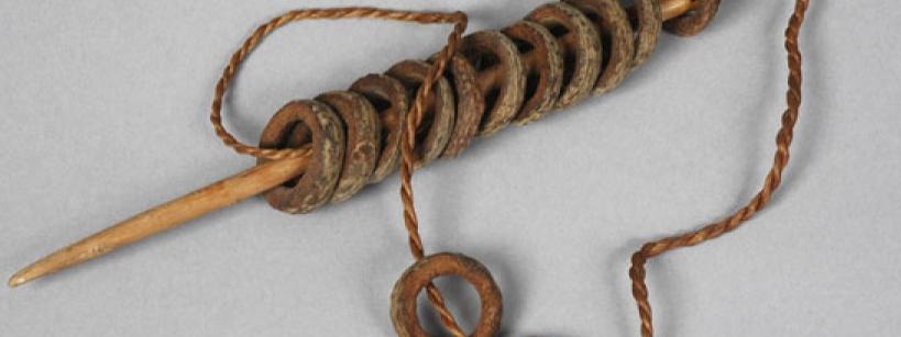 wooden rings on a stick with a cord threaded through them