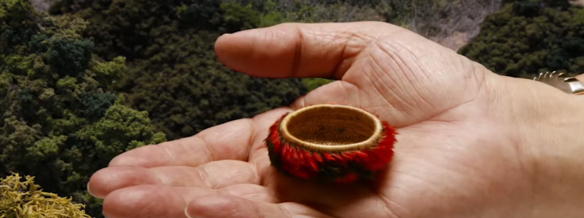 hand holds miniature feathered basket